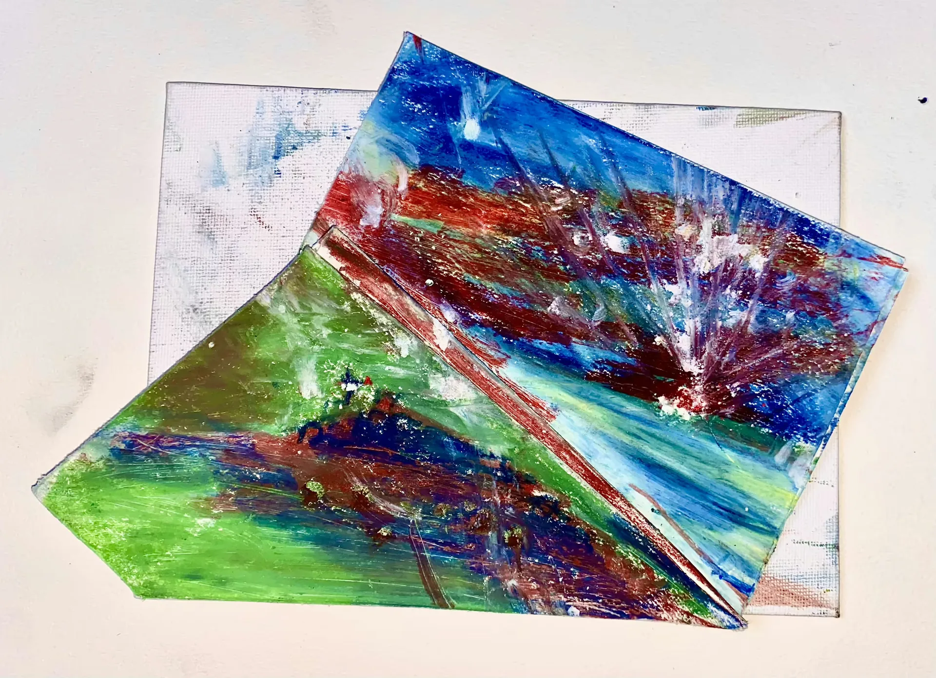 Three overlapping abstract works on paper combine green, blue, red and violet paint with diagonal marks.