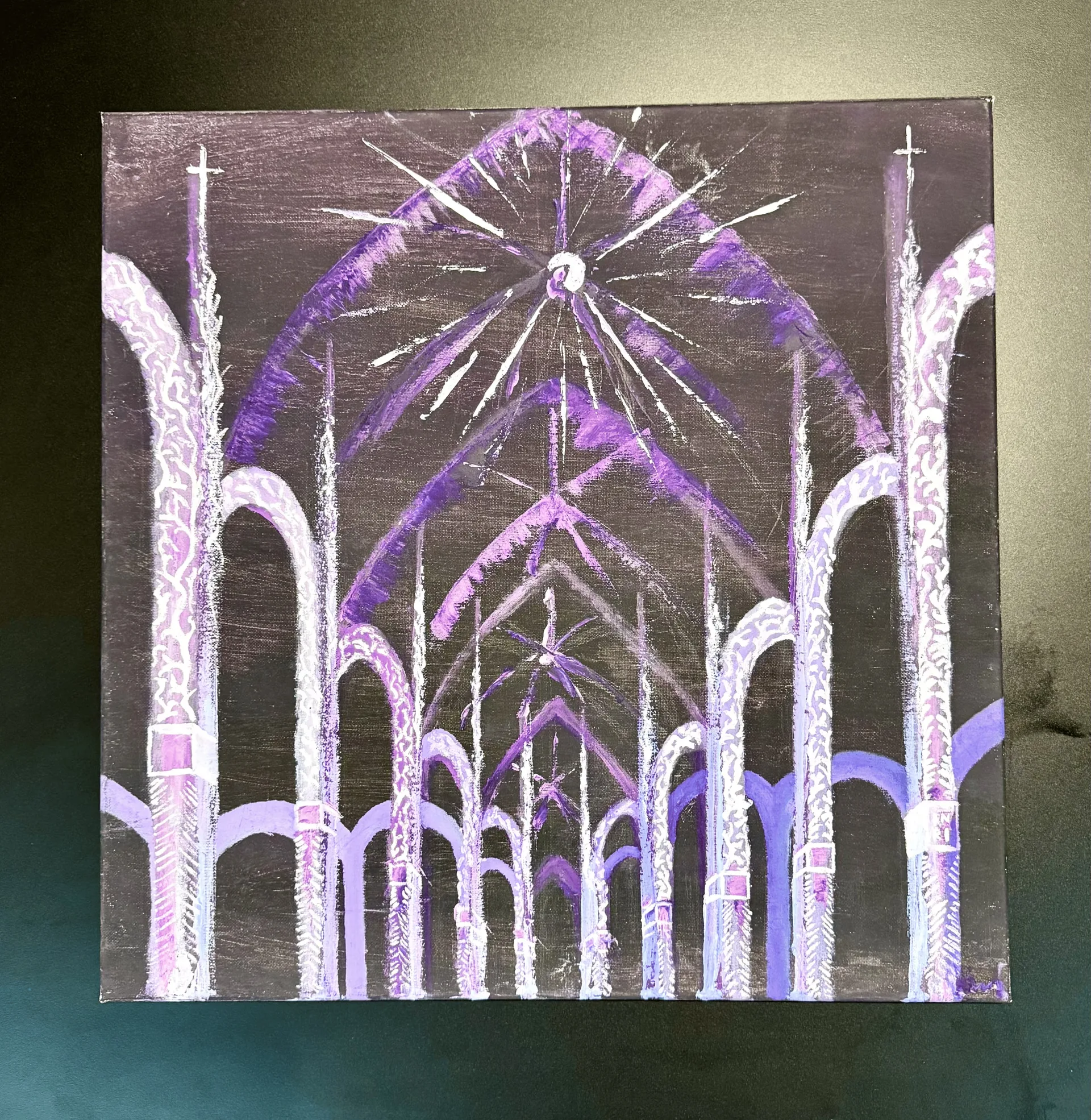 The square canvas photographed against a dark olive backdrop, its pale columns and radiating vault glowing out of the near-black ground.
